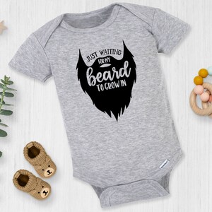 May include: A gray baby onesie with a black beard graphic and the text "Just waiting for my beard to grow in".