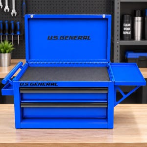 Puede incluir: Una caja de herramientas de metal azul brillante con dos cajones, una tapa abatible y un estante lateral. El logotipo U.S. GENERAL está impreso en negro en la parte frontal y en el interior de la tapa. El interior tiene un forro de espuma negra.