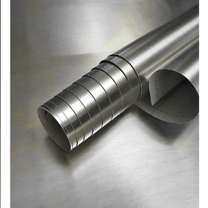 Puede incluir: Un rollo de chapa de acero inoxidable cepillado. El metal est&aacute; enrollado apretadamente y tiene un acabado cepillado.