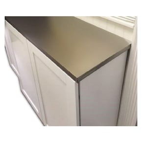 Puede incluir: Primer plano de un armario blanco con una encimera de acero inoxidable. La encimera tiene una superficie lisa y reflectante.