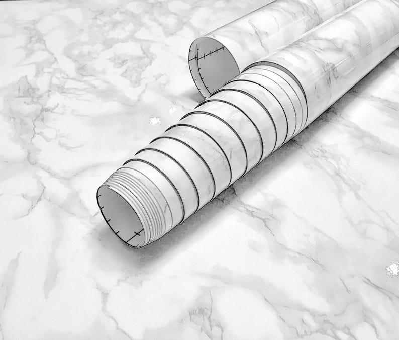 May include: A roll of white marble contact paper with a gray veining pattern. The paper is rolled up and the end is visible.