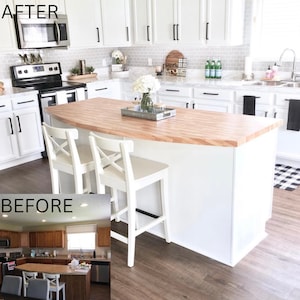 May include: Before and after kitchen renovation with a white kitchen island with a butcher block countertop and two white bar stools. The island is in front of white cabinets with black hardware. The floor is a light wood laminate.