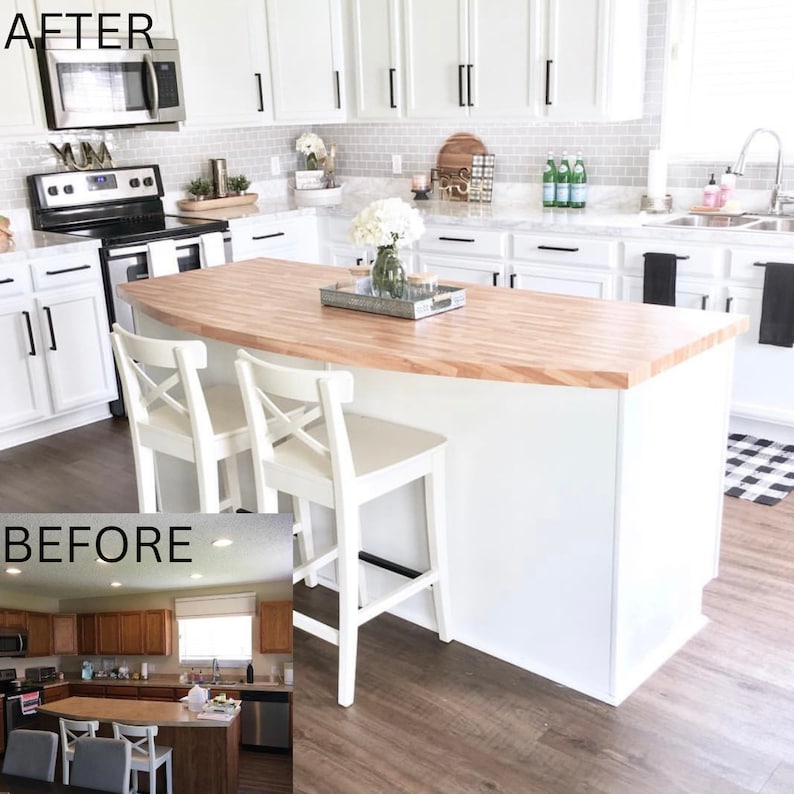 May include: Before and after kitchen renovation with a white kitchen island with a butcher block countertop and two white bar stools. The island is in front of white cabinets with black hardware. The floor is a light wood laminate.
