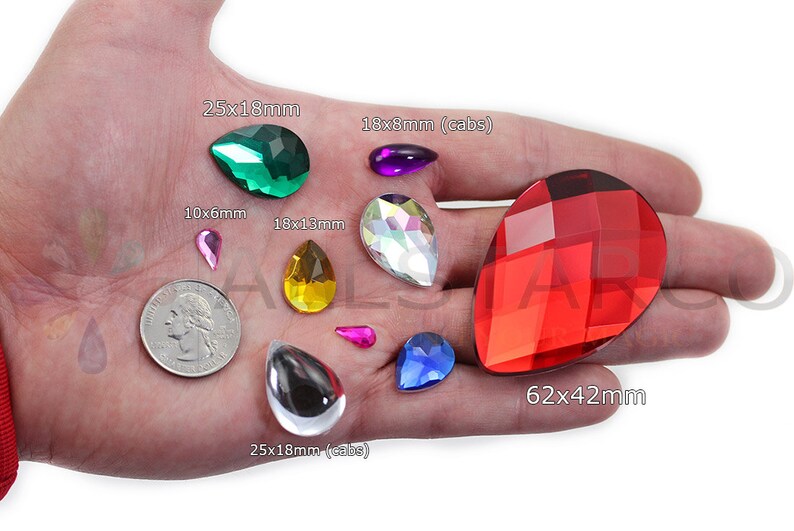 May include: Assorted teardrop-shaped gemstones in various colors, including green, purple, yellow, iridescent, pink, blue, and red. Sizes range from 10x6mm to 62x42mm. A US quarter is included for size comparison.