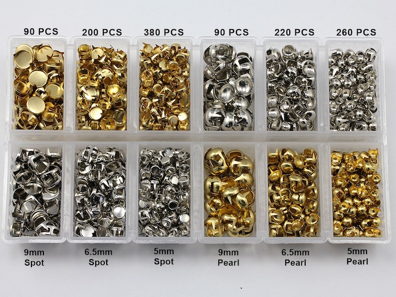 May include: A clear plastic organiser containing various metal embellishments. The embellishments include gold and silver spots and pearls in different sizes, with quantities ranging from 90 to 380 pieces. The sizes are 5mm, 6.5mm, and 9mm.