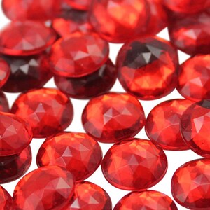 May include: A scattering of red faceted glass gems, perfect for crafting or decorating.