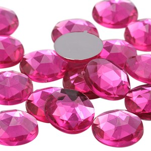 Peut inclure: Un groupe de gemmes rondes en plastique facettées de couleur rose. Les gemmes sont éparpillées sur une surface blanche.