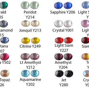 May include: A collection of faceted, round gemstones in various colors, including emerald, sapphire, and amethyst. Each color is labeled with its name and a corresponding code. The gemstones are displayed in pairs, showcasing their brilliance.