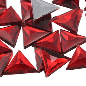 May include: A scattering of red triangular rhinestones, perfect for adding sparkle to crafts and jewelry.
