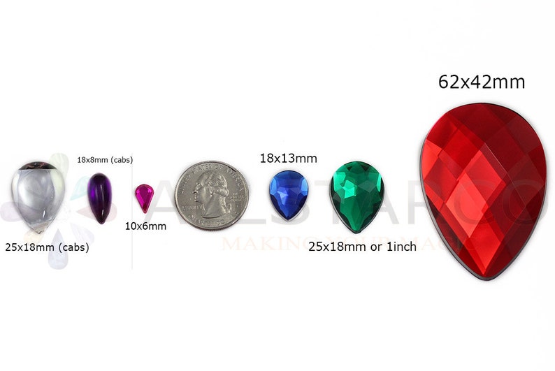 May include: Assortment of teardrop-shaped gemstones in various colors and sizes. Includes clear, purple, pink, blue, and green stones, with a large red faceted stone measuring 62x42mm. Sizes range from 10x6mm to 25x18mm (cabs) or 1 inch.