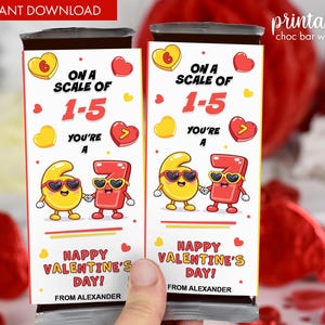 Pode incluir: Duas embalagens de barras de chocolate com tema de Dia dos Namorados. As embalagens apresentam o texto "Em uma escala de 1-5, você é um 7" com números de desenhos animados de mãos dadas. As embalagens também dizem "Feliz Dia dos Namorados!" e "De Alexander."