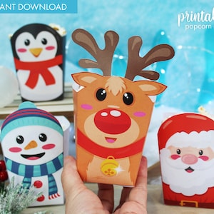 Peut inclure: Boîtes à popcorn de Noël imprimables avec un pingouin, un bonhomme de neige, un renne et le Père Noël. Les boîtes sont décorées de couleurs et de motifs festifs.