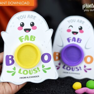 May include: Two printable ghost-shaped play dough holders with the text "You are Fab-Boo-lous!" and a space for play dough. The ghosts have cute cartoon faces and are white with purple and green accents.