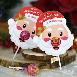 Puede incluir: Dos soportes de piruletas con forma de Pap&aacute; Noel con gorros rojos y barbas blancas. Las piruletas son rojas y blancas y tienen el texto "A Little Christmas Treat for Someone So Sweet!" en los soportes.