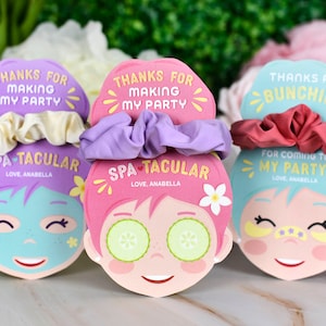 K&ouml;nnte beinhalten: Drei Partygeschenke zum Thema Spa mit Scrunchies. Jedes Geschenk zeigt ein Cartoon-Gesicht mit dem Text "Danke, dass du meine Party gemacht hast" und "Spa-tacular". Eines hat Gurkenscheiben auf den Augen, ein anderes Augenpflaster und das dritte eine Gesichtsmaske.