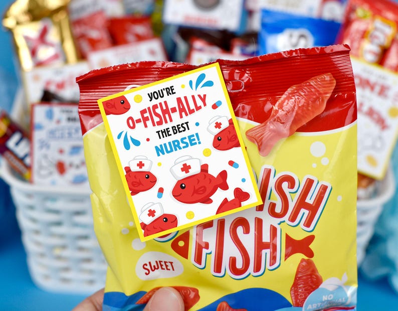 Puede incluir: Una bolsa roja y amarilla de caramelos de pescado gomoso con una etiqueta que dice "You're O-Fish-Ally the Best Nurse!" La etiqueta tiene un pez de dibujos animados con un gorro de enfermera.