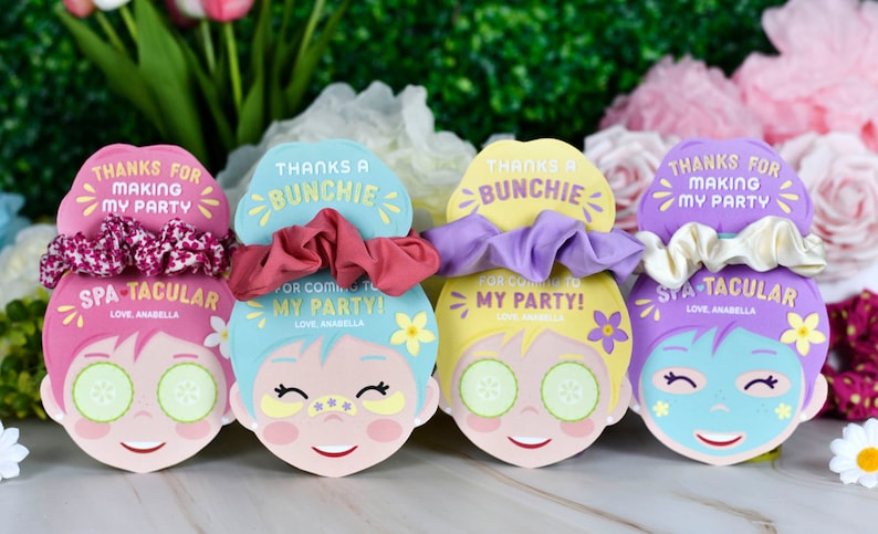 K&ouml;nnte beinhalten: Vier Party-Gef&auml;lligkeiten zum Thema Spa mit Scrunchies. Jede Gef&auml;lligkeit zeigt ein Cartoon-Gesicht-Design mit Gurkenscheiben, Augenpflastern und Gesichtsmasken. Der Text enth&auml;lt "Danke, dass du meine Party gemacht hast" und "Spa-tacular."