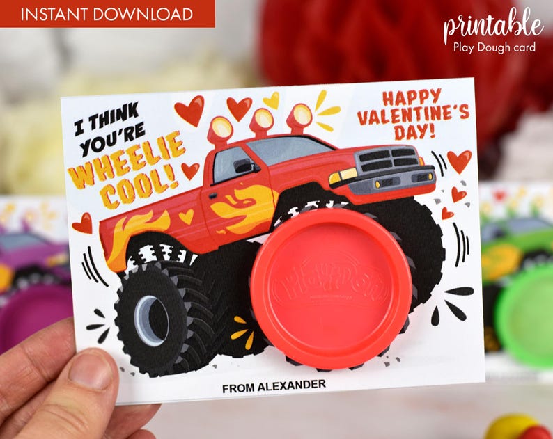 May include: A red monster truck with flames on the side and a play dough container attached to the side. The card says "I think you're wheelie cool!" and "Happy Valentine's Day!"