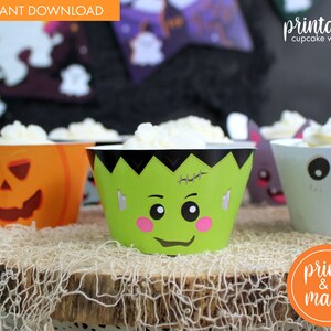 May include: Printable Halloween cupcake wrappers featuring a pumpkin, Frankenstein, and ghost design. The wrappers are printed on white paper with colorful illustrations. The text "printable cupcake wrappers" is visible in the top right corner of the image.