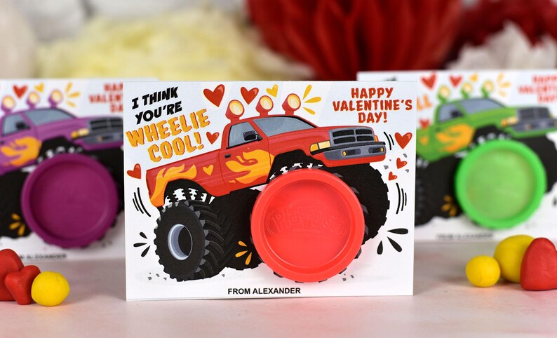 May include: A Valentine's Day card featuring a red monster truck with the text "I think you're wheelie cool!" and "Happy Valentine's Day!" The card has a red play dough container attached to it.