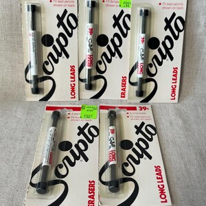 May include: Several Scripto Long Leads and Erasers packages are displayed. Each package features a black and white design with the Scripto logo and product information. The packages are sealed with a clear plastic, showcasing the lead pencils.