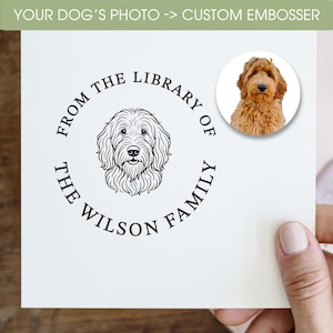 May include: A custom embosser with the text "YOUR DOG'S PHOTO -> CUSTOM EMBOSSER" at the top. The embosser features a line drawing of a dog in the center, surrounded by the words "FROM THE LIBRARY OF THE WILSON FAMILY". A color photo of a dog is in the upper right corner.