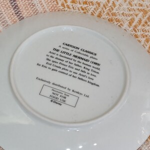 Puede incluir: Un plato de cer&aacute;mica blanco con texto de la pel&iacute;cula animada de Disney "La Sirenita" (1989). El plato incluye texto sobre Ariel, el Rey Trit&oacute;n, el Pr&iacute;ncipe Eric y &Uacute;rsula. Es un art&iacute;culo decorativo, no apto para uso alimentario.
