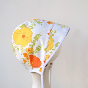 Baby-Sonnenhaube mit gelben und orangen Blumen, von Neugeborenen bis Kleinkindergrößen auf Bestellung