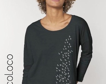 Könnte beinhalten: Ein dunkelgraues Langarmshirt mit einem Vogelschwarm-Design, das auf der rechten Seite des Shirts gedruckt ist.