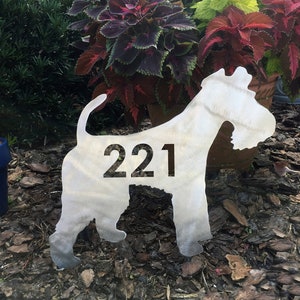 May include: A metal silhouette of a dog with the house number 221 cut out. The silhouette is standing on a bed of brown mulch.