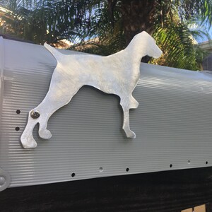 May include: A gray metal mailbox with a silver metal dog silhouette attached to the front. The dog is standing on its hind legs with its front paws raised.