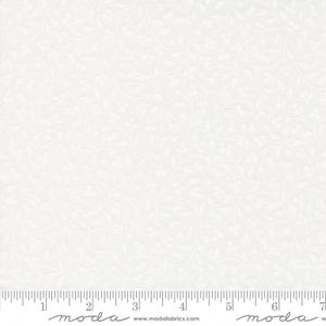 May include: A white fabric featuring a subtle, tonal pattern of delicate leaves and small berries. A ruler is visible at the bottom edge, showing measurements in inches, with the text "moda" and "www.modafabrics.com" printed along the selvage.