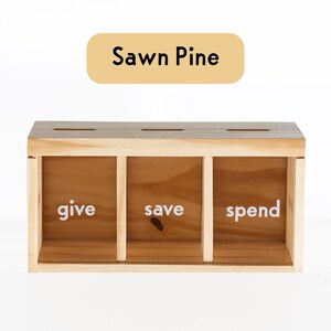 Puede incluir: Caja de madera con tres compartimentos etiquetados como "give", "save" y "spend". La caja est&aacute; hecha de pino serrado.