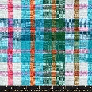 Op de afbeelding: Een geweven stof met een veelkleurig ruitpatroon met verticale en horizontale strepen in tinten felroze, turquoise, oranje, donkergroen en wit. Een zwarte liniaal aan de onderkant toont een schaal van 17,78 cm.