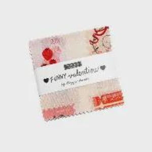 May include: A stack of fabric squares with a Valentine's Day theme. The fabric features a light pink and cream background with red hearts and candy designs. A white band with the text "Funny Valentine!" wraps around the squares.