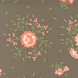 Può includere: Un tessuto marrone con un motivo ripetitivo di fiori rosa corallo e foglie verdi. I fiori hanno un centro bianco e sono circondati da piccole bacche rosa corallo.