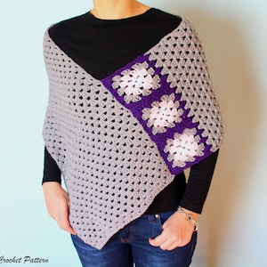 May include: A gray crochet poncho with a purple and pink granny square design. The poncho is worn by a person with a black shirt and blue jeans.