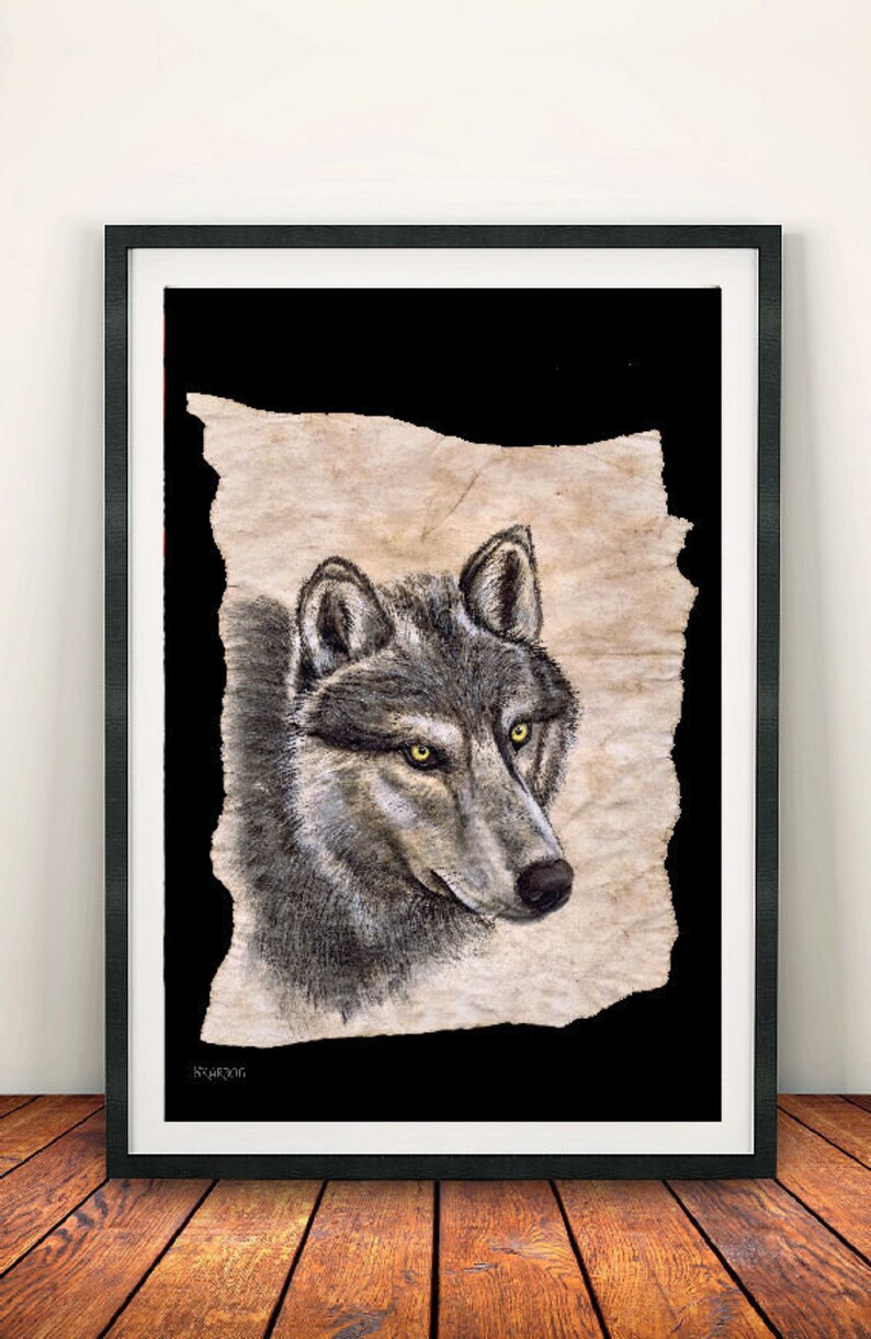 May include: A black and white drawing of a wolf's head on a textured, beige paper background. The wolf has a grey fur coat and bright yellow eyes. The drawing is framed in a black frame.
