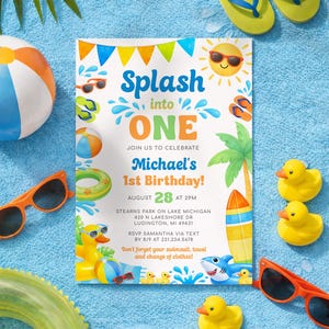 May include: A beach-themed birthday invitation with the text "Splash into ONE" and "Michael's 1st Birthday!" surrounded by beach toys, sunglasses, and rubber ducks. The invitation is on a blue towel.