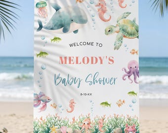 May include: A rectangular welcome sign for a baby shower featuring watercolor illustrations of a dolphin, sea turtle, octopus, seahorses, and fish. The text reads WELCOME TO MELODY'S Baby Shower 8-10-XX against a white background with coral.