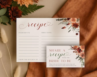 Puede incluir: Tarjetas de recetas con detalles florales. La tarjeta principal tiene espacio para ingredientes e instrucciones, con la palabra "recipe" en cursiva. Una tarjeta más pequeña dice "Share a recipe with the bride to be."