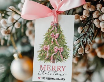 May include: A pink and green Christmas gift tag with a watercolor illustration of a Christmas tree decorated with pink bows. The text "Merry Christmas" is written in pink and black script with a heart and the text "The Williamson Family" below.