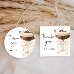 May include: Two white gift tags with a coffee drink illustration and the text "Thank you Abigail".