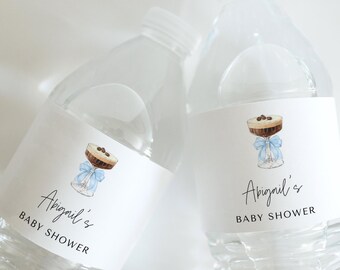 May include: Two clear plastic water bottles with white labels. Each label features a watercolor illustration of a cocktail with a blue bow and the text "Abigail's BABY SHOWER" in elegant script.