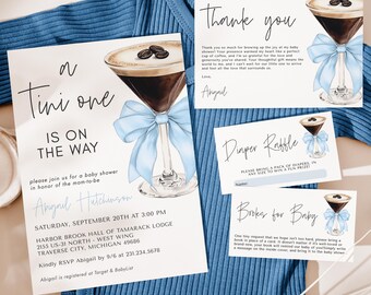 May include: A baby shower invitation with a blue and white color scheme. The invitation features a martini glass with a blue bow and the text "A Tini One Is On The Way". The invitation also includes the date, time, and location of the shower.