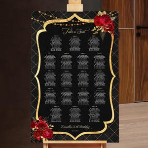 May include: A black seating chart with gold accents and a decorative frame. The chart includes guest names organized by table, with the words "Take a Seat" at the top. Red floral decorations adorn the top right and bottom left corners.