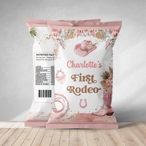 May include: Pink and gold chip bag with a floral design and the text "Charlotte's First Rodeo".