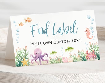 May include: Printable food label with an under the sea theme. The label features an octopus, fish, starfish, seashells, and a crab. The text on the label reads "Food Label" and "Your Own Custom Text".