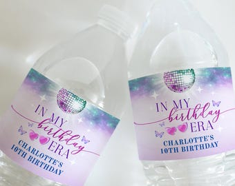 May include: Two clear plastic water bottles with purple, blue and green iridescent labels. The labels feature a disco ball, butterflies, and the text "In My Birthday Era" and "Charlotte's 10th Birthday".