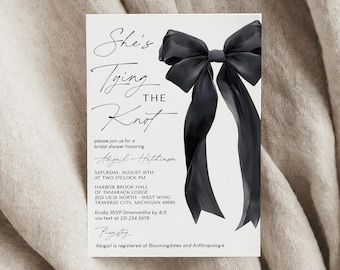 May include: A white bridal shower invitation with black calligraphy text that reads "She's Tying the Knot". The invitation features a large black satin bow with a watercolor effect.